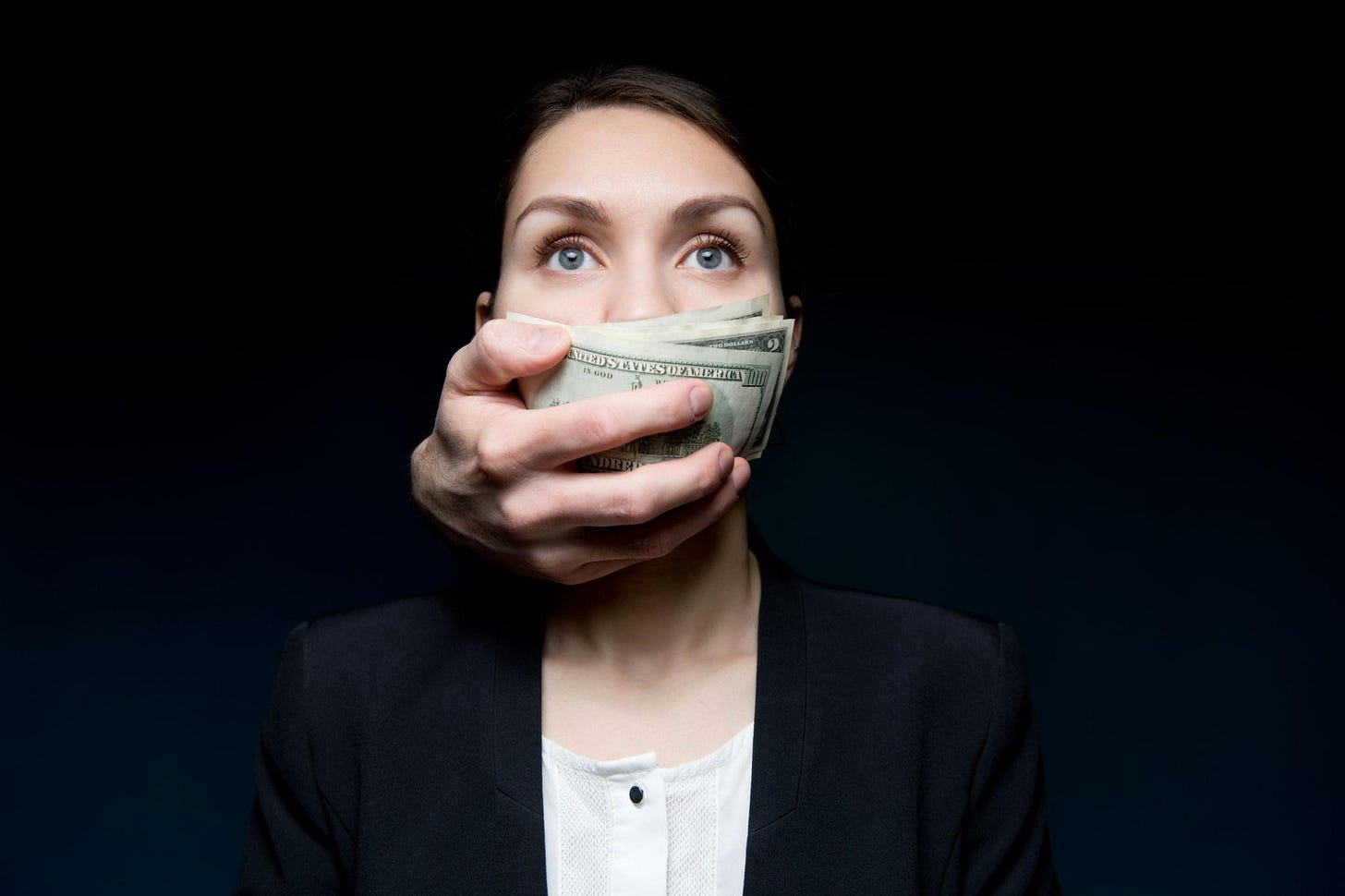 Corruption cover the woman s mouth with money. woman looking into the void
