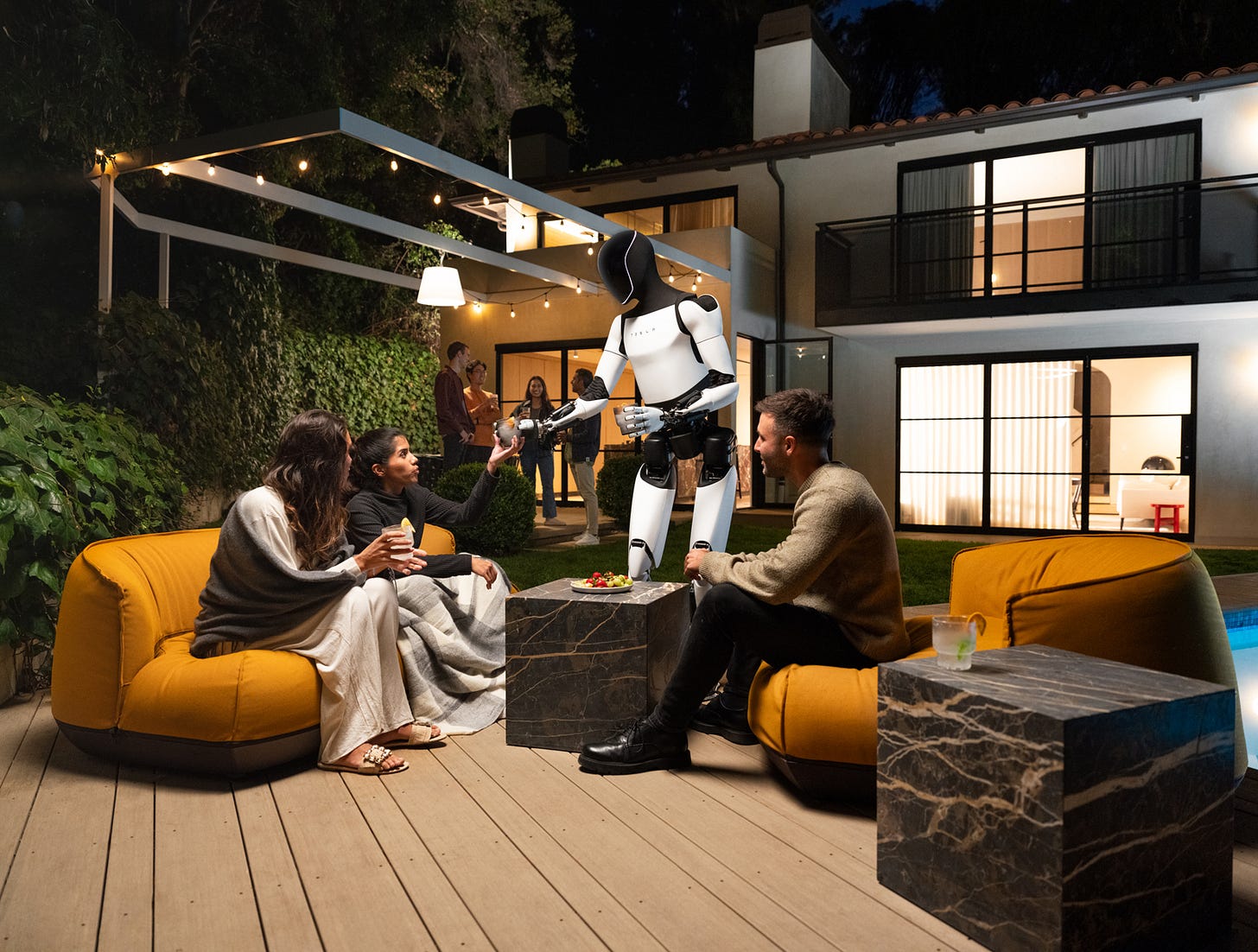 A Tesla Optimus robot serves a family at night on a patio.