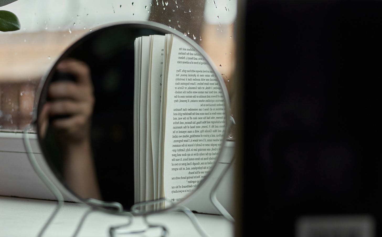 A book reflected in a mirror with a window in the background. Photo by Vladyslav Tobolenko on Unsplash