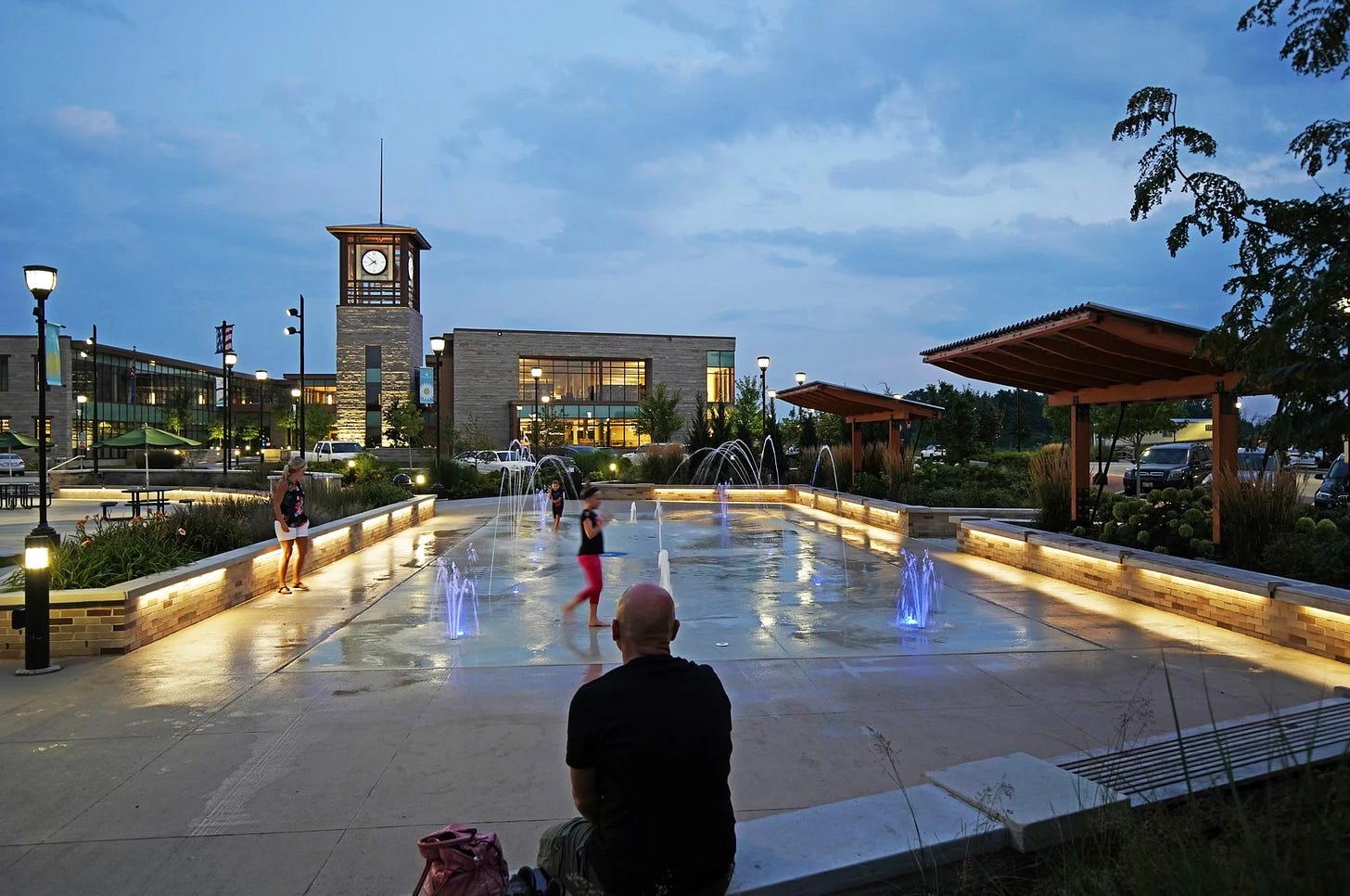 people enjoying a splash pad in the evening