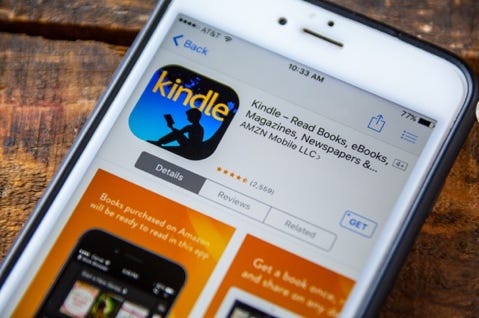 iphone with the reading app (Kindle) displayed on the screen iphone with the reading app (Kindle) displayed on the screen