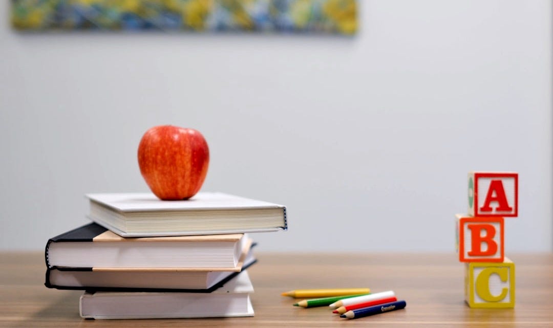 red apple fruit on four pyle books