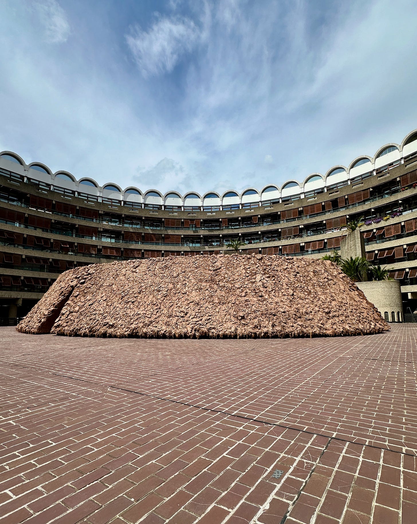 The clay installation of Origo on the brick pavers of the Barbican in London
