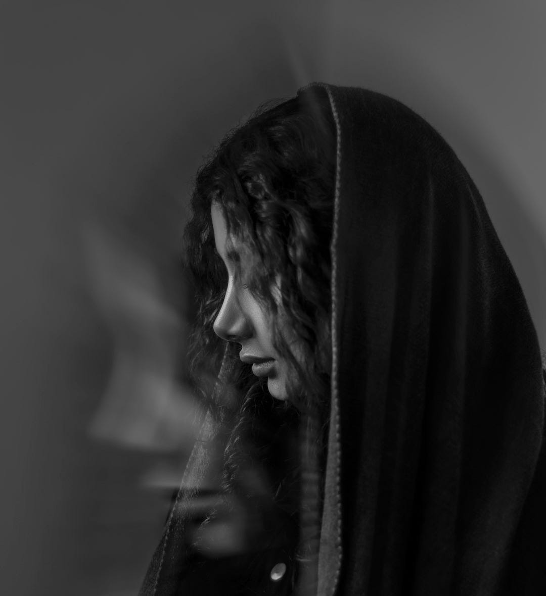 a black and white photo of a woman wearing a hood a black and white photo of a woman wearing a hood
