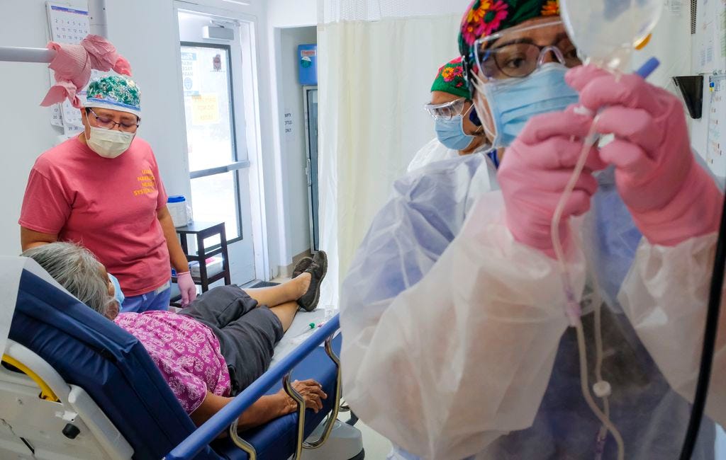 (Leah Hogsten  |  The Salt Lake Tribune) Navajo Mountain Health Clinic Manager Revina Talker tends to a 74-year-old Diné patient as medical assistant Toni Black gets an IV flowing, Aug., 25, 2020. “I think we’re going to have to get ready for the next round,” said Talker of her staff’s autumn response to the coronavirus and the impending flu season. The Navajo Nation has been hit hard by the pandemic.