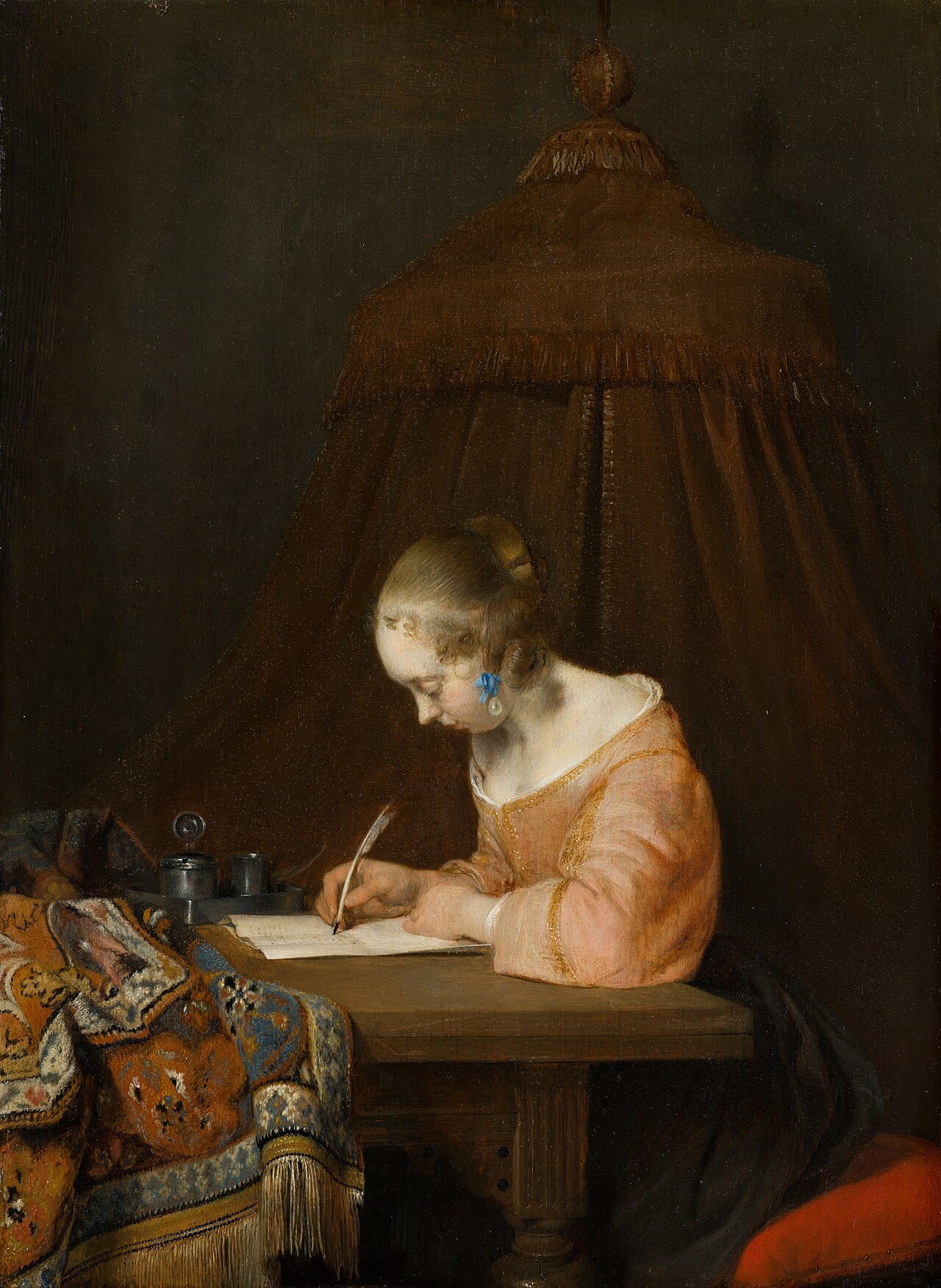 A young woman alone writing at a table in satin A young woman alone writing at a table in satin