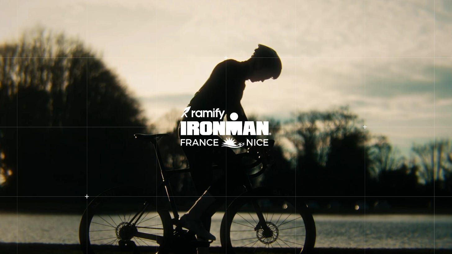 Man on a bike in the background, with the Ramify Ironman Nice logo in the foreground