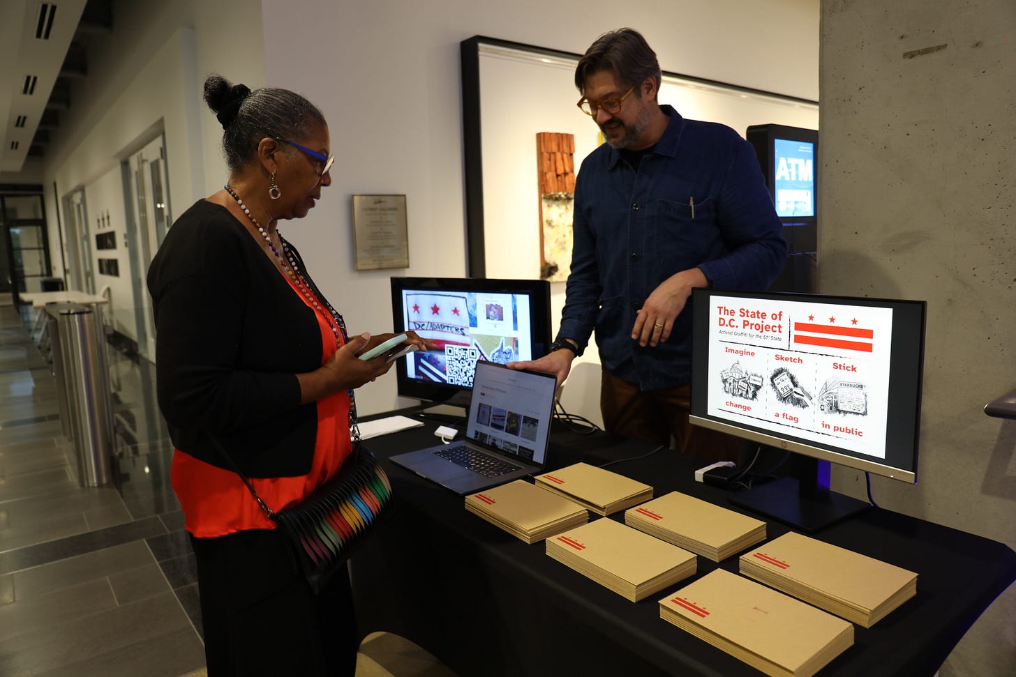 A participant talks with a presenter at a table