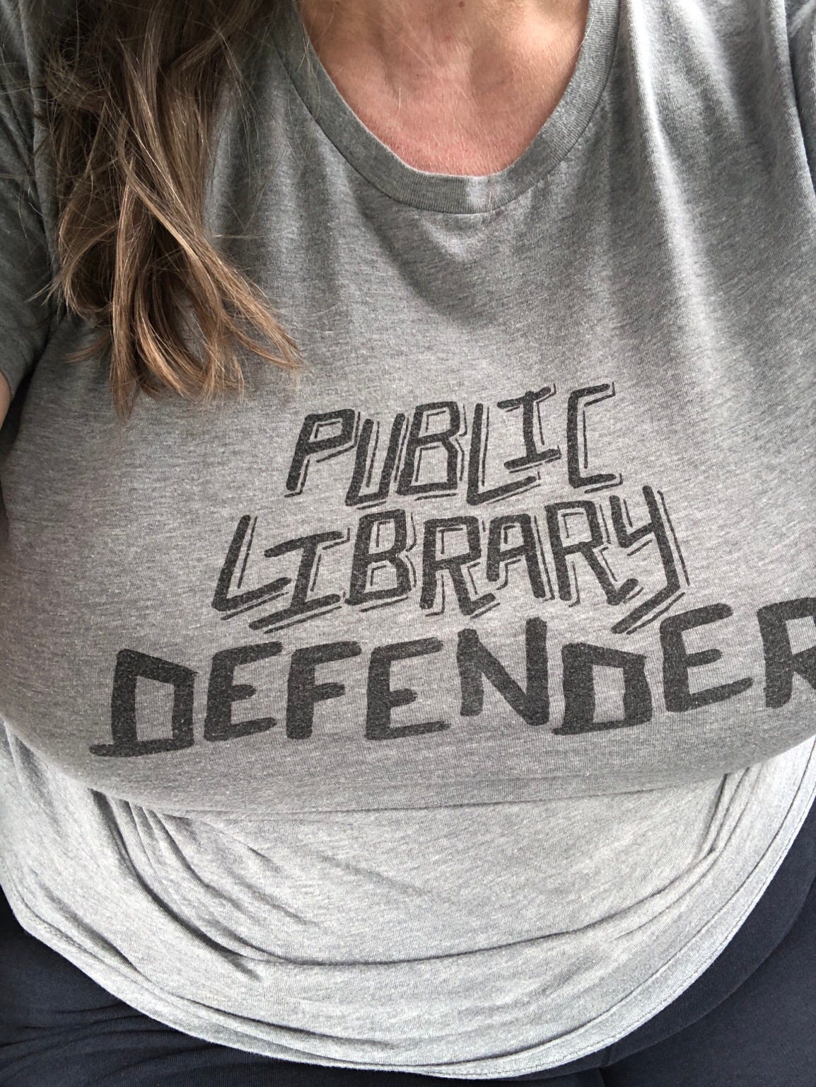 gray t-shirt on Sue reads "Public Library Defender" gray t-shirt on Sue reads "Public Library Defender"