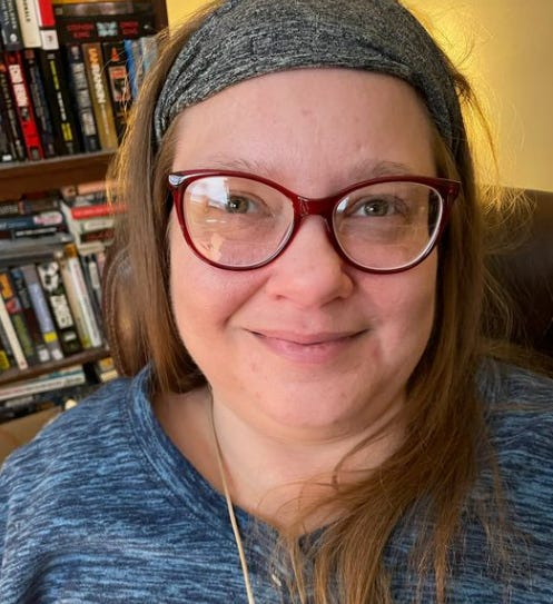 Sarah Terzo, a red-haired woman with glasses 