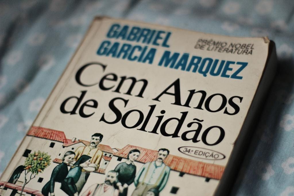capa da edição antiga do livro cem anos de solidão, de gabriel garcia marquez, com um desenho de uma família e algumas casas ao fundo.