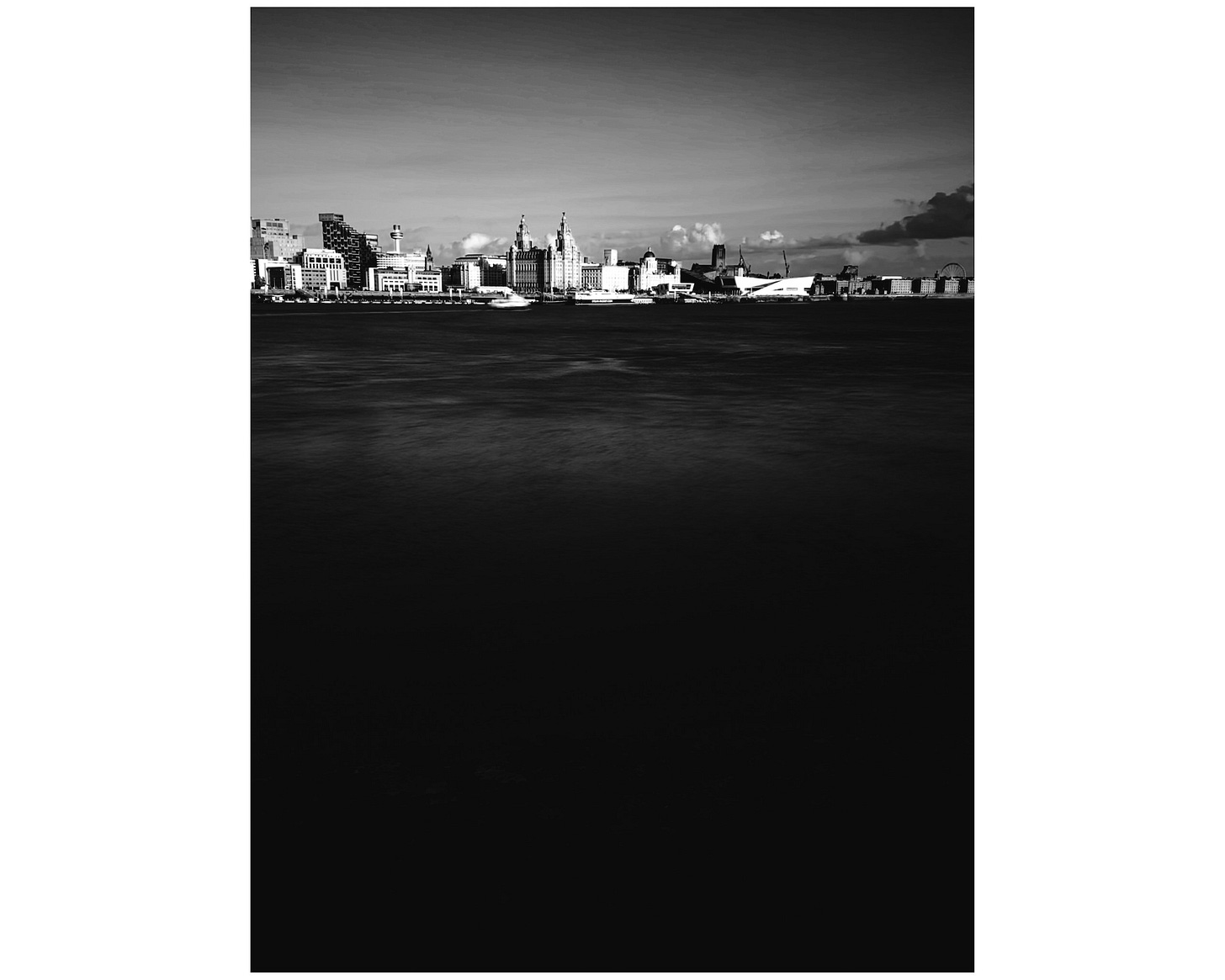The Liverpool waterfront in black and white in early evening light.