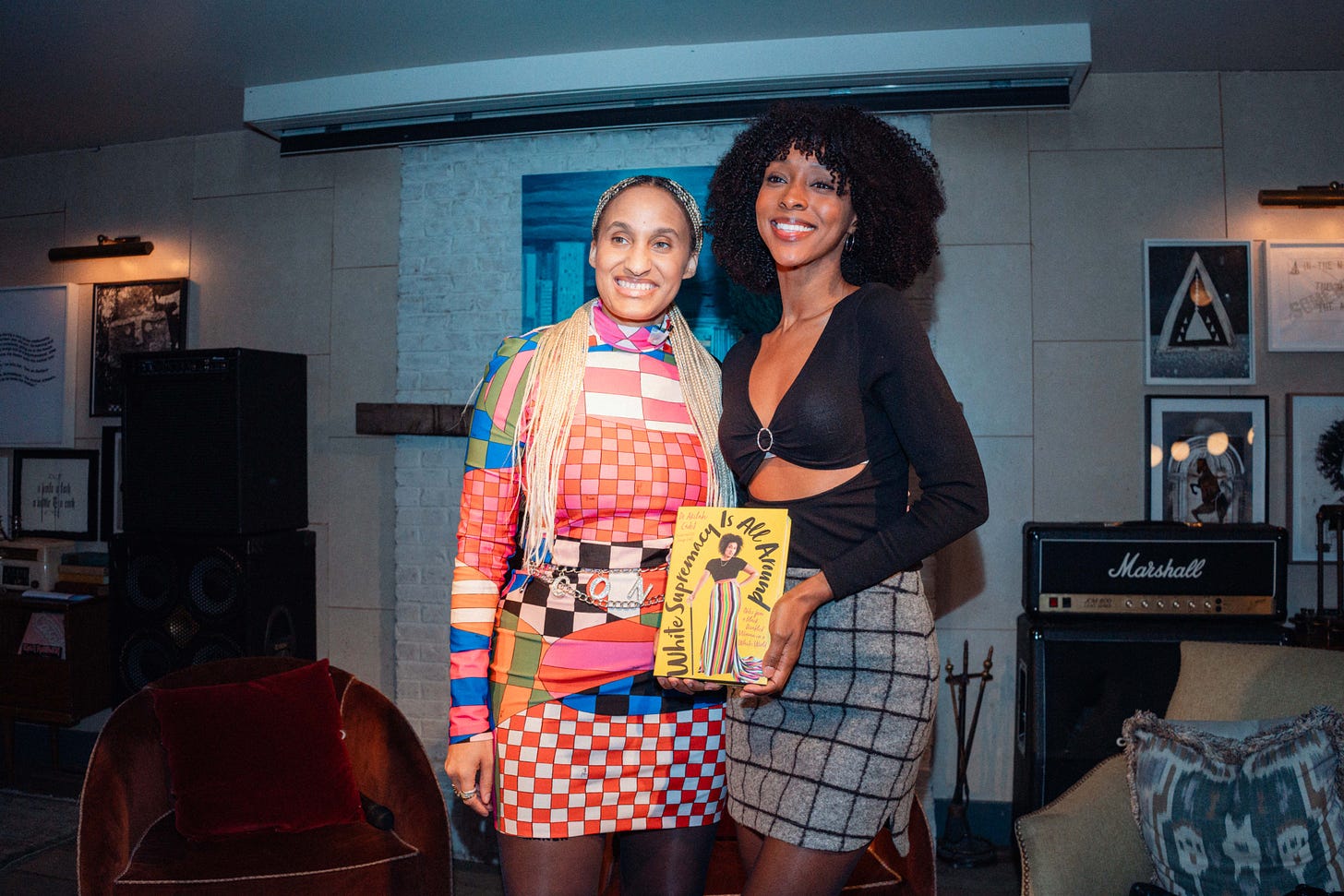 Dr. Cadet gives us a rare smile as she stands next to Ebony Obsidian, talent on and off screen (must watch Six Triple Eight), shines as much as her bright smile, milk chocolate complexion, and full natural dark brown curls. Holding Dr. Cadet’s yellow book, she wears a cut out black long sleeve top with a patterned gray wool skirt. The bright multi-color, multi-print, Pucci turtleneck midi bodycon dress is where Dr. Cadet’ golden braids rest. This is what Black women celebrating Black women look like.