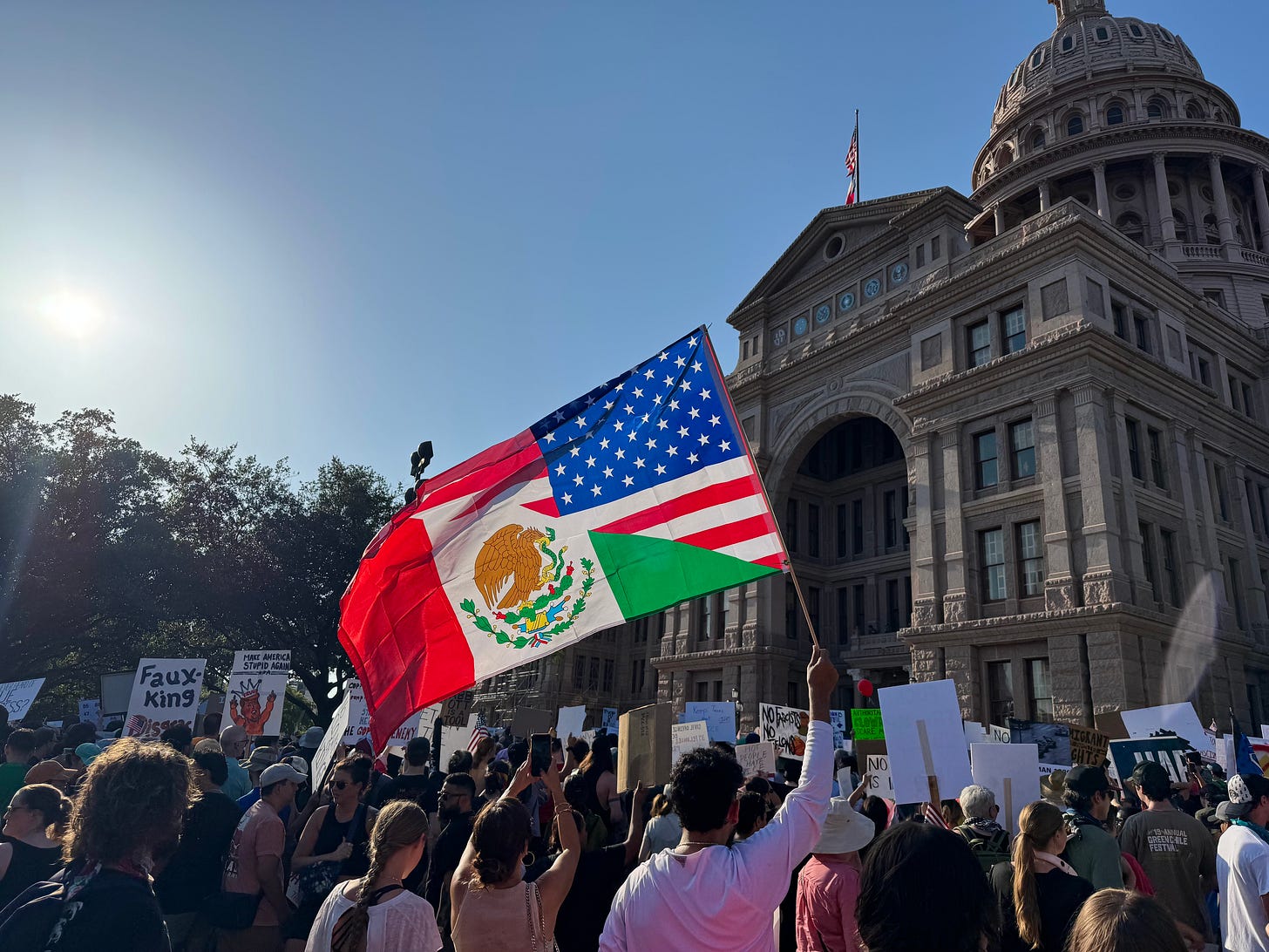 Protest at Texas Capitol with flag combining US & Mexican flags flying in foreground