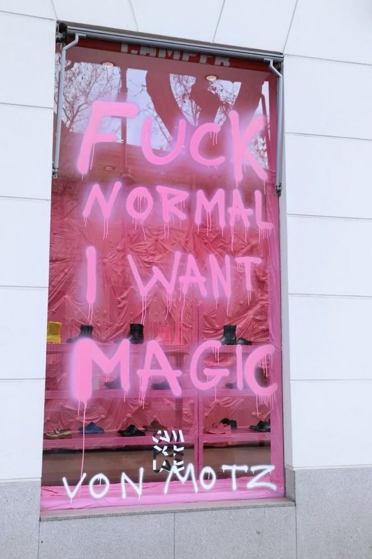 This may contain: graffiti on the side of a building in front of a pink sign that says i want magic
