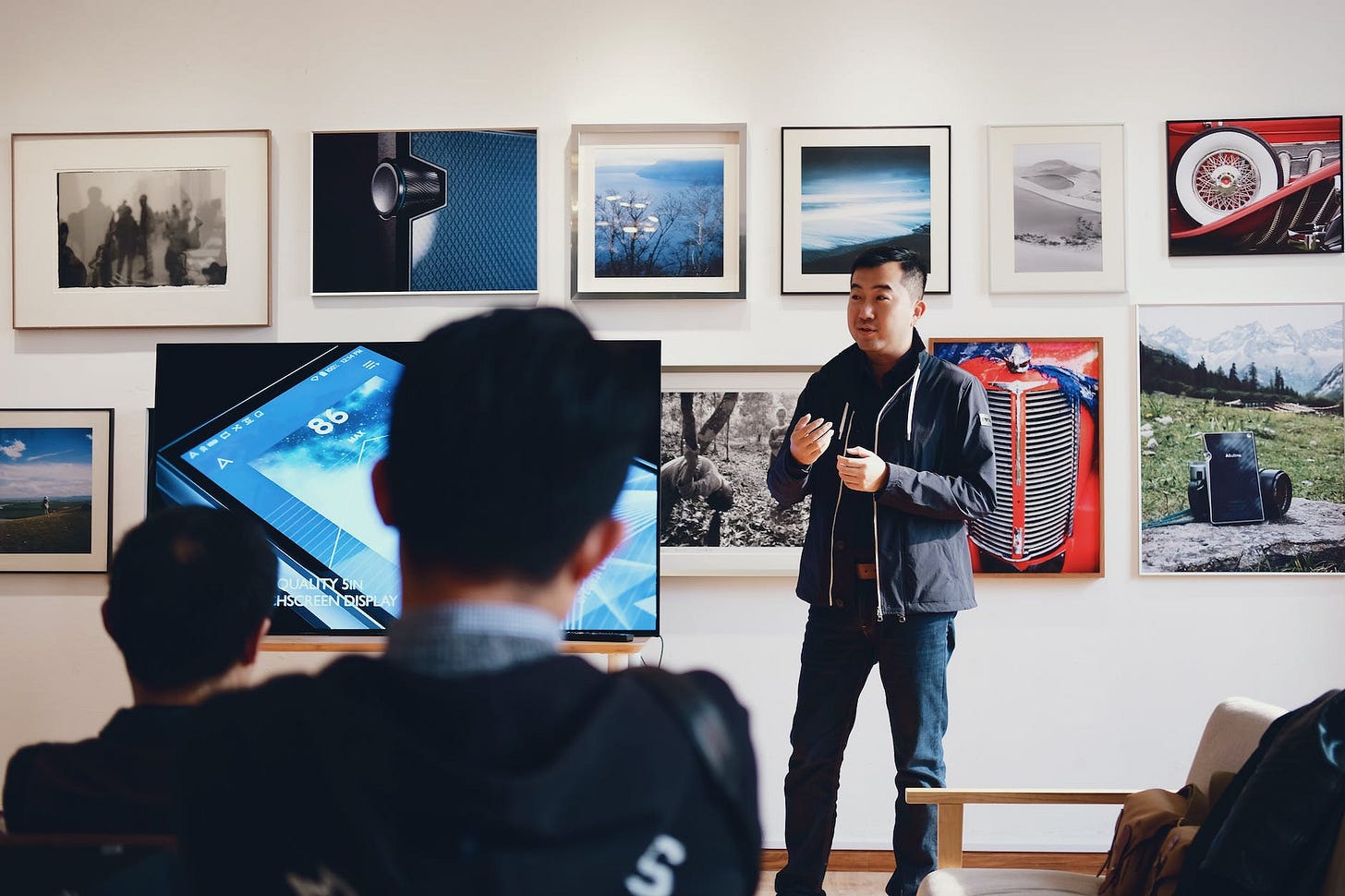 man beside flat screen television with photos background talking about ways to improve self-esteem