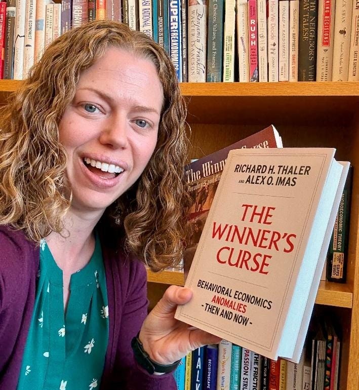 A person holding a book in front of a bookshelf

AI-generated content may be incorrect.