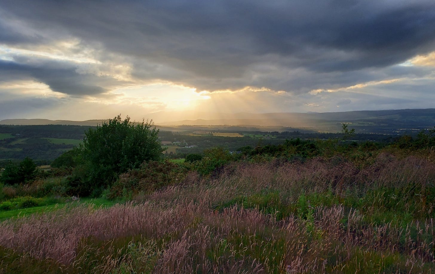 Evening sun breaking through clouds over beautiful wild hills and countryside in the north of Scotland