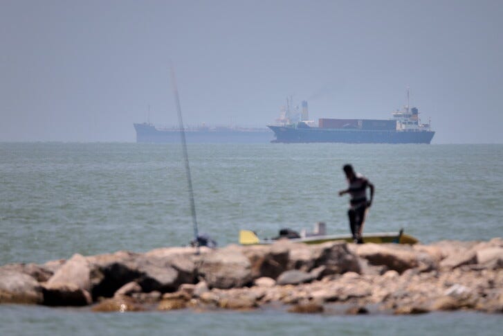 A man stands beside a fishing pole along the shore as cargo ships and commercial vessels are seen in the Strait of Hormuz off Bandar Abbas, Iran, Wednesday, June 17, 2026. (Amirhosein Khorgooi/ISNA via AP) A man stands beside a fishing pole along the shore as cargo ships and commercial vessels are seen in the Strait of Hormuz off Bandar Abbas, Iran, Wednesday, June 17, 2026. (Amirhosein Khorgooi/ISNA via AP)