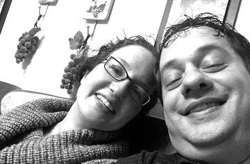 Black and white candid selfie of Angela and her brother Tony, cheek to cheek, both smiling with their eyes closed. Angela rests her head against Tony's shoulder. A wall of framed botanical prints with grapevines hangs behind them. The last photo ever taken of them together. Black and white candid selfie of Angela and her brother Tony, cheek to cheek, both smiling with their eyes closed. Angela rests her head against Tony's shoulder. A wall of framed botanical prints with grapevines hangs behind them. The last photo ever taken of them together.