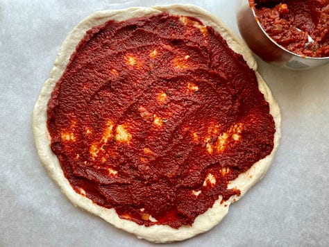 Pressed biscuit crust layered with enough tomato paste to kill a small bison, parmesan, baked beans, and a pile of mozzarella and green pepper slices right in the middle where they can't do anyone any good