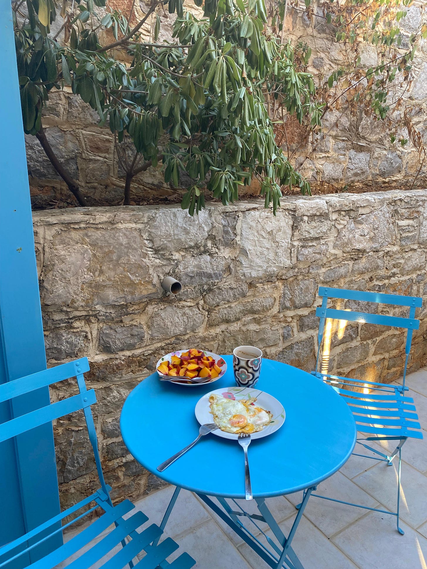 colourful breakfast table with eggs, coffee and peaches in a porch