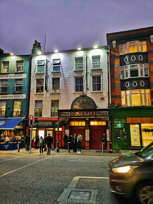 A white building in a night-time street.