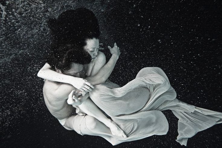 Man and woman embrace underwater Man and woman embrace underwater