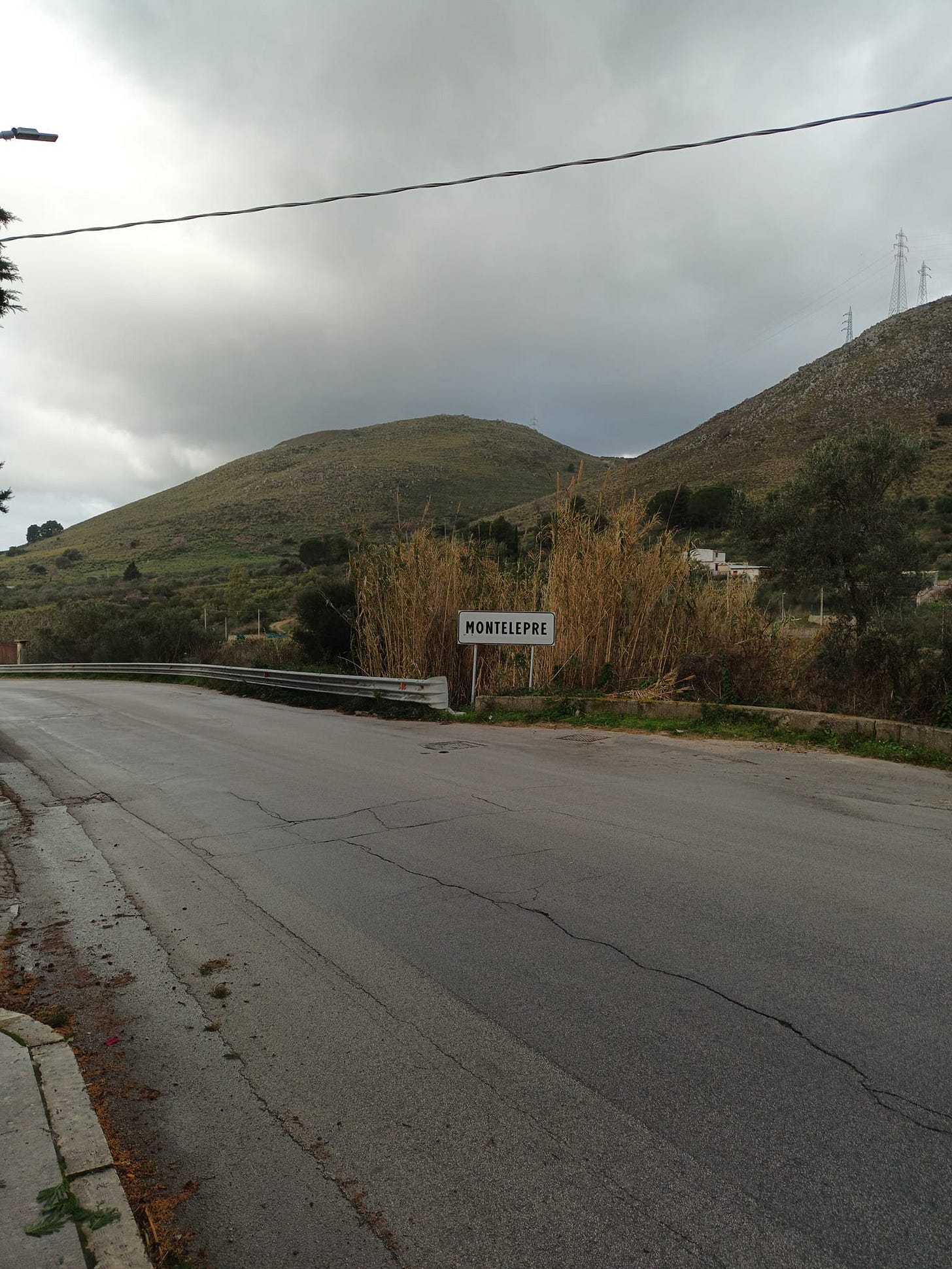 May be an image of mountain, road, grass and fog