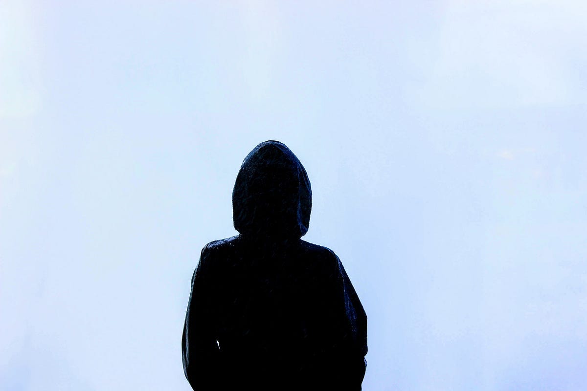Silhouette of a person wearing a hood Silhouette of a person wearing a hood