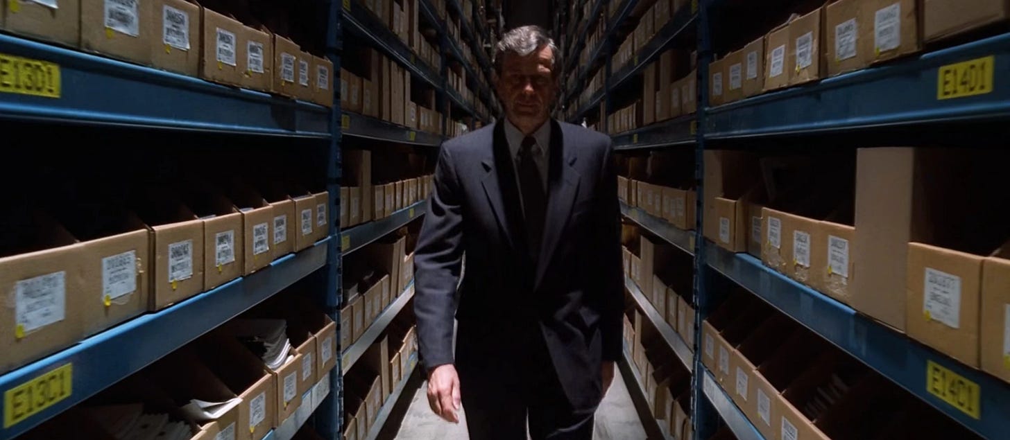 The Cigarette Smoking Man from The X-Files walks the halls of his secret vault in the Pentagon full of alien paranphenelia 