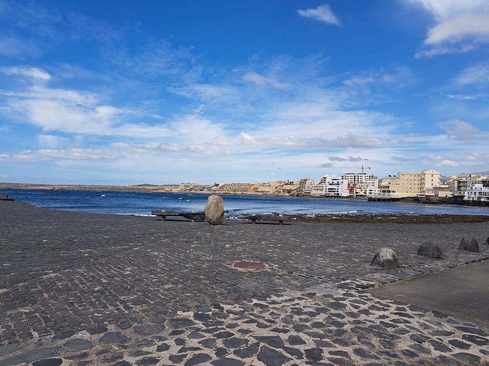 The view of El Medano from the pier. Under a warm blue sky.