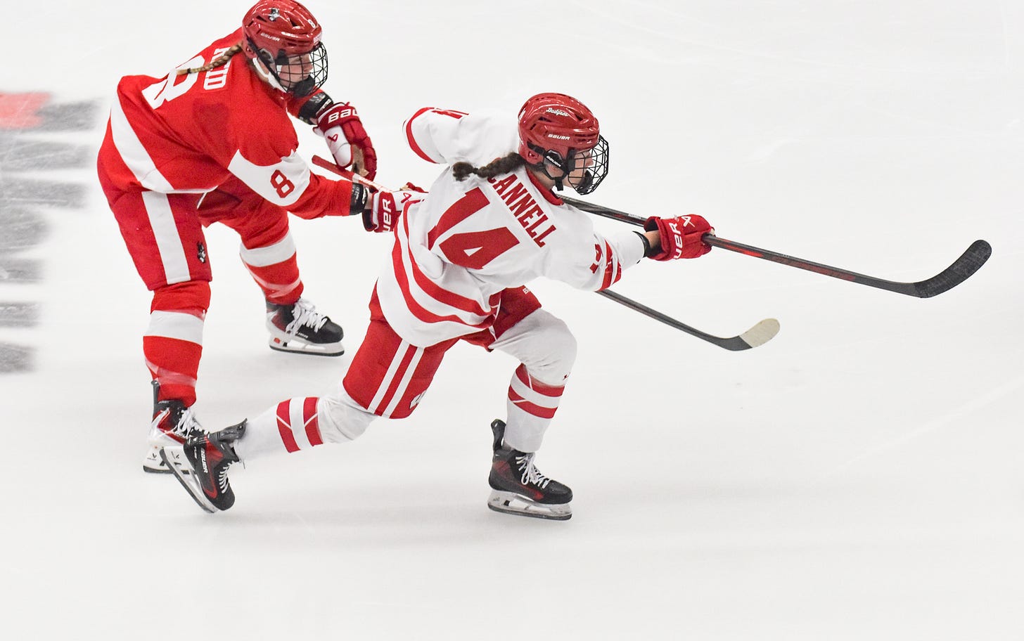 Wisconsin women's hockey forward Maggie Scannell extends her stick toward the net while a BU skater defends behind her