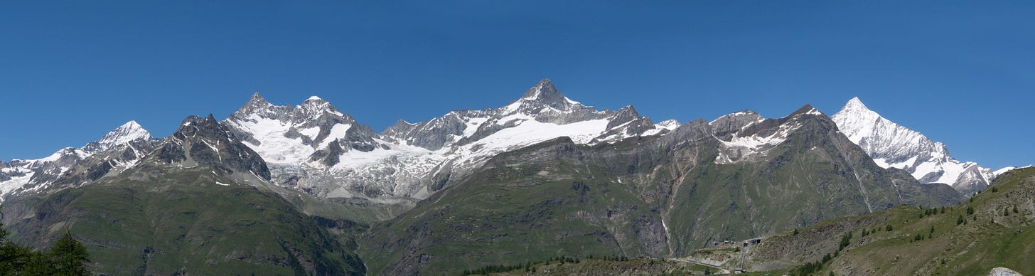 four snowy mountains against the sky