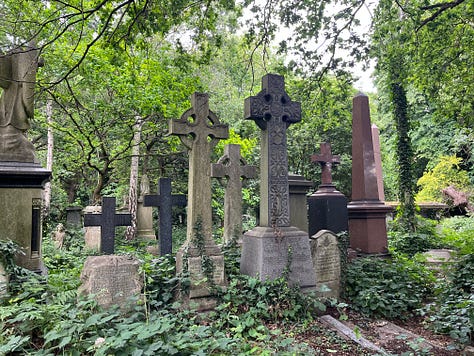 Several Victorian Celtic cross grave monuments in an overgrown cemetery
