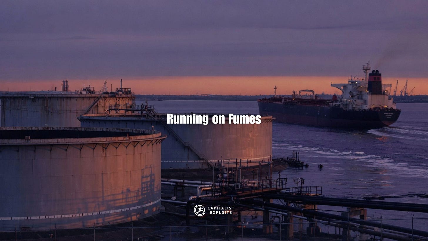 Industrial oil refinery with storage tanks and tanker ship at sunset harbor