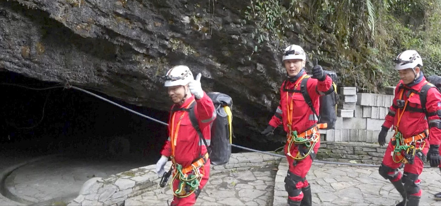 Cai Xuzhe (left), Jiang Xinlin (center), and Tang Shengjie (right) entering the cave in December 2025 to participate in the training exercise.