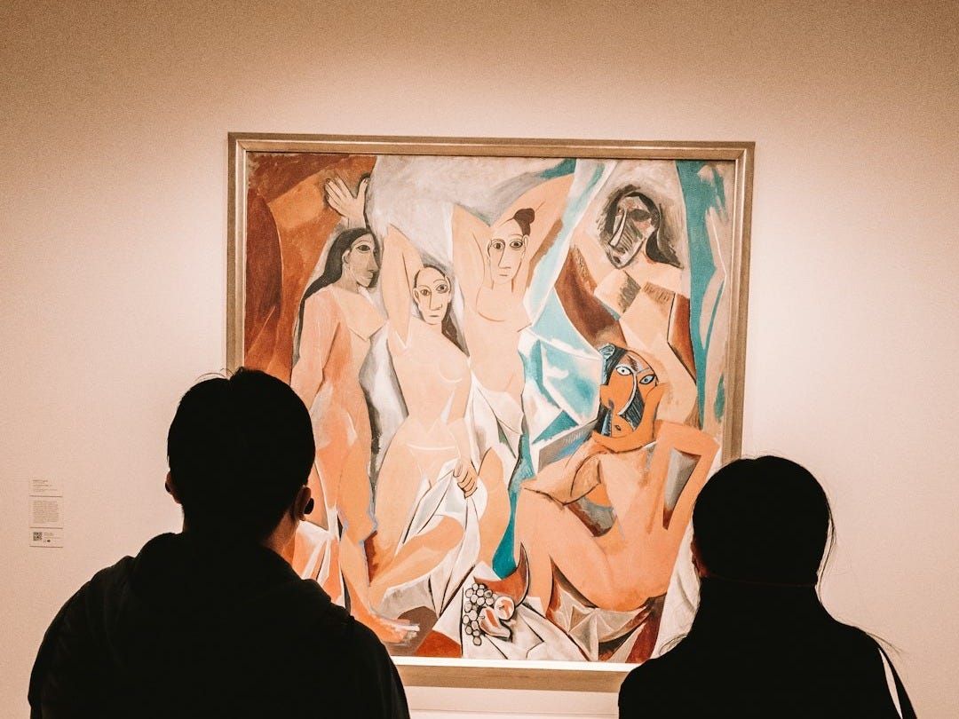 two people looking at a painting in a museum