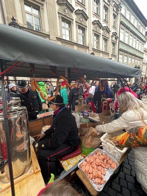 Masked figures in fur and straw costumes during Prague's Masopust, the Czech pre-Lenten carnival.