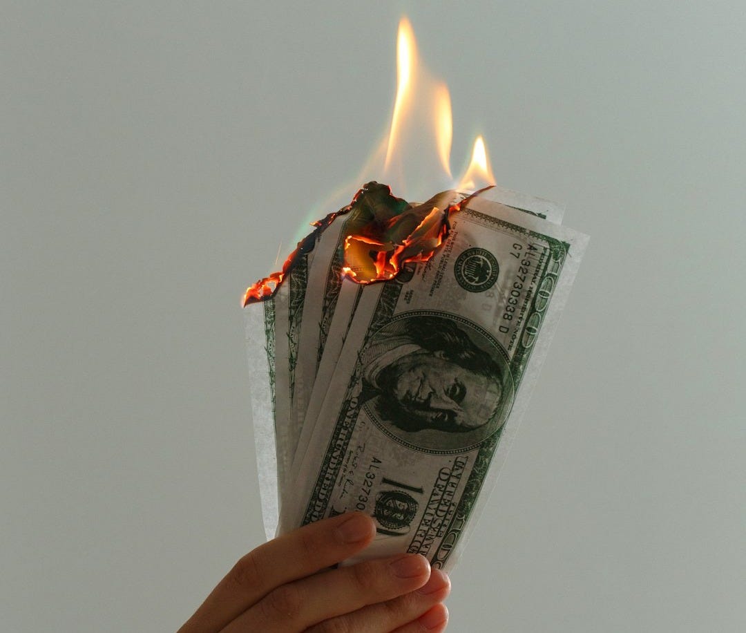 time lapse photography of several burning US dollar banknotes