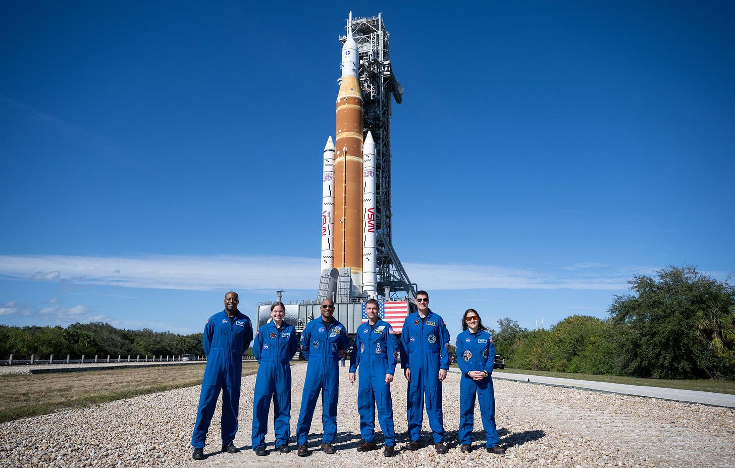 From left: Artemis II backup crewmembers NASA astronaut Andre Douglas and CSA (Canadian Space Agency) astronaut Jenni Gibbons and prime crewmembers NASA astronauts Victor Glover, Reid Wiseman, CSA (Canadian Space Agency) astronaut Jeremy Hansen, and NASA astronaut Christina Koch, pose for a picture with NASA’s Space Launch System (SLS) rocket and Orion spacecraft, secured to the mobile launcher, as it makes the 4.2 mile journey from the Vehicle Assembly Building to Launch Pad 39B, Saturday, Jan. 17, 2026, at NASA’s Kennedy Space Center in Florida.