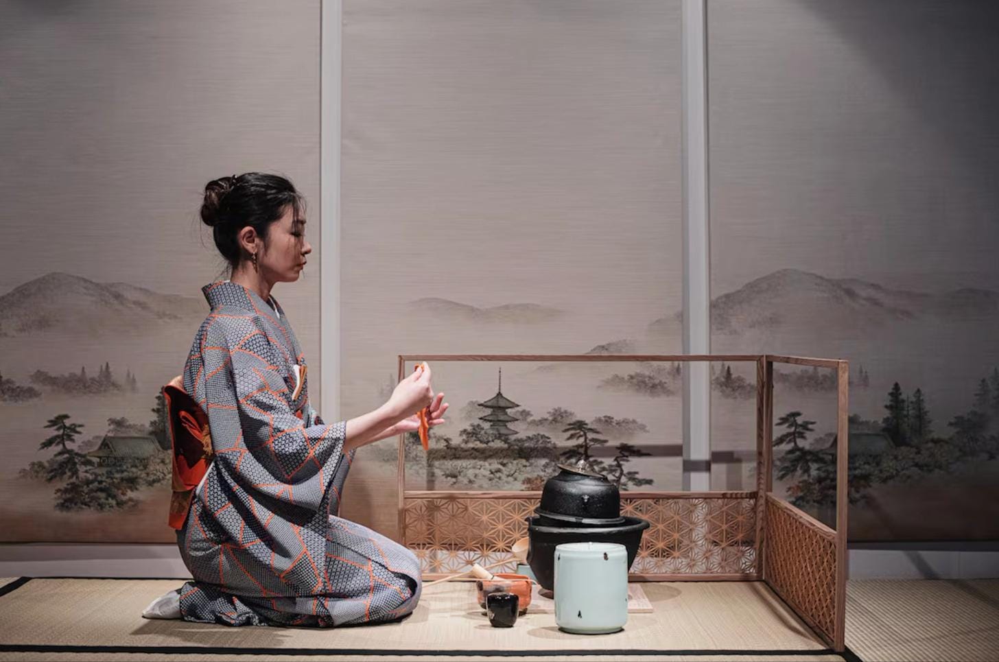 Woman performing a traditional Japanese tea ceremony while preparing matcha Woman performing a traditional Japanese tea ceremony while preparing matcha