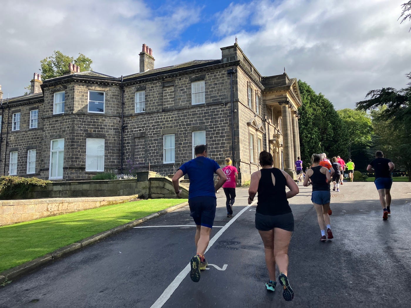 Conyngham Hall on the left, runners on a road to the right