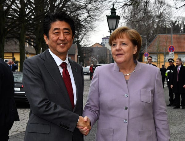 Photos of Angela Merkel, chancellor of German, dressed in blazers of various colors, speaking at a podium and shaking the hands of world leaders 