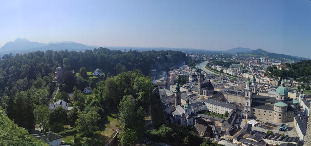 A view of Salzburg from the fortress showing the river and several green-copper domes, including the cathedral.