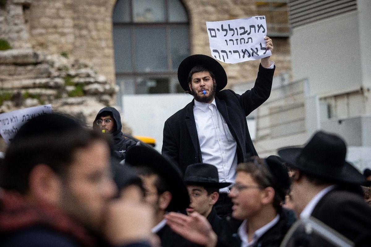 Ultra-Orthodox Jews scuffle with police as they protest members of the Women of the Wall movement bringing in Torah scrolls to their hold Rosh Hodesh prayers at the Western Wall in Jerusalem Old City, March 4, 2022. Sign translation: "Assimilators go back to America." (Photo by Yonatan Sindel/Flash90) Ultra-Orthodox Jews scuffle with police as they protest members of the Women of the Wall movement bringing in Torah scrolls to their hold Rosh Hodesh prayers at the Western Wall in Jerusalem Old City, March 4, 2022. Sign translation: "Assimilators go back to America." (Photo by Yonatan Sindel/Flash90)