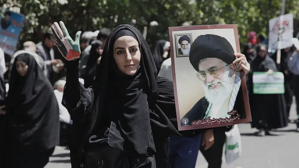 Uma mulher carrega um cartaz do Líder Supremo Ali Khamenei em Teerã, Irã. Shutterstock