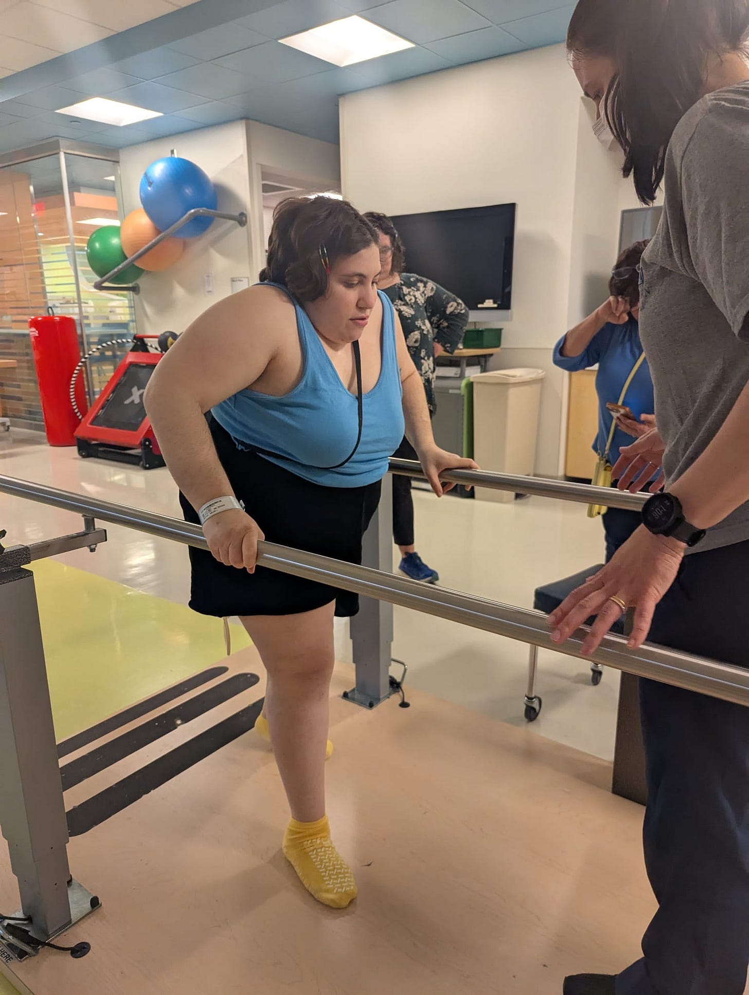 Using parallel bars at the hospital physical therapy gym to relearn how to walk after my hip replacement.