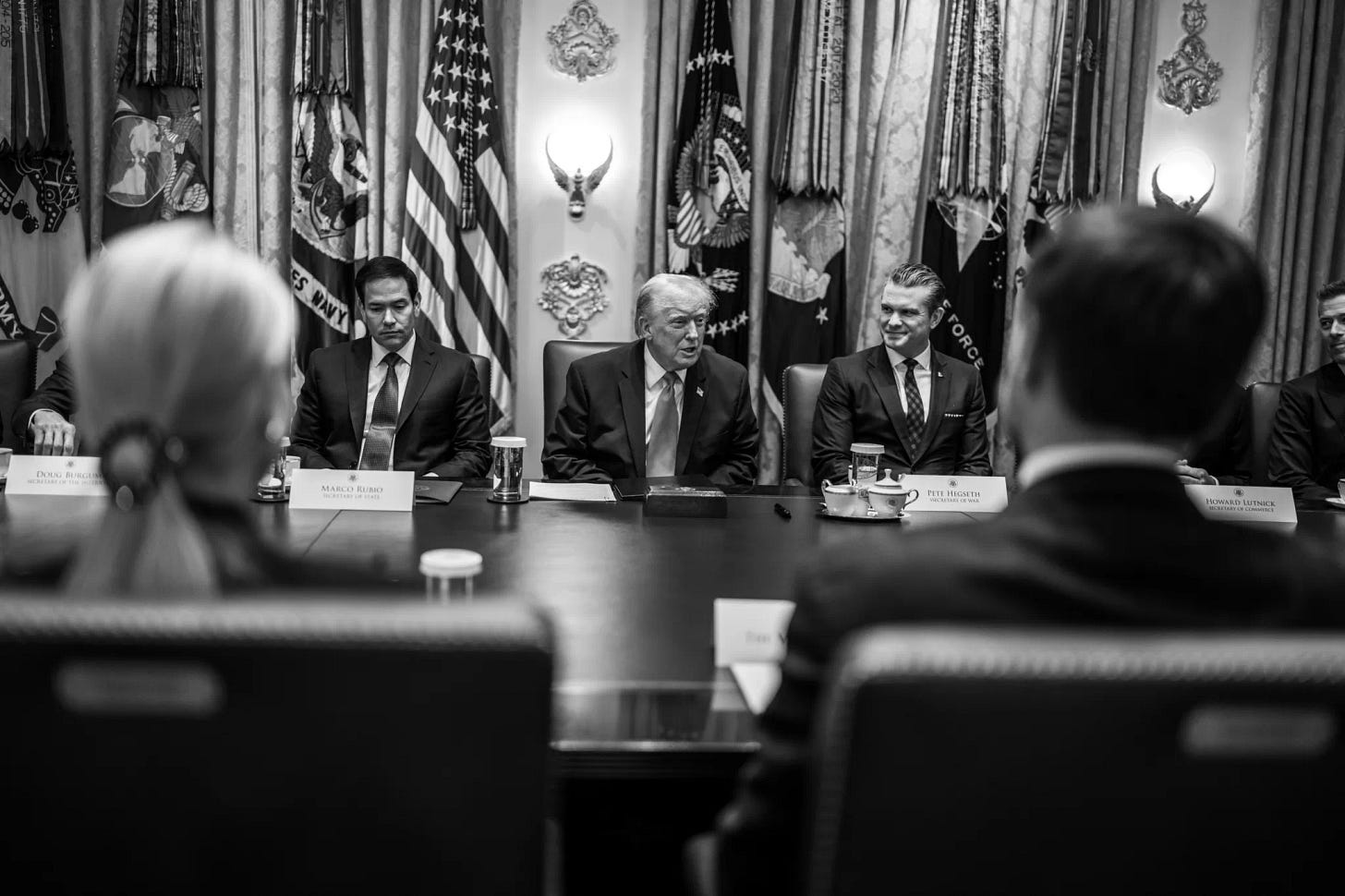 official whitehouse.gov black and white photograph shows President Trump speaking to his Cabinet.