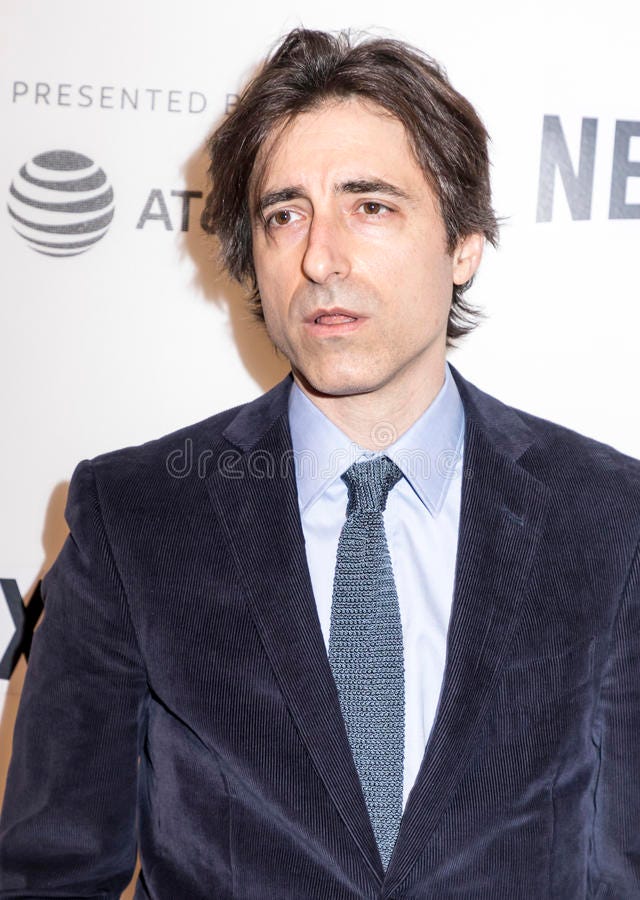 A picture of Noah Baumbach. His hair line is subtly receding, and he has wavy, graying, messy hair. Arguably, his facial structure resembles that of Adam Driver in the White Noise image.